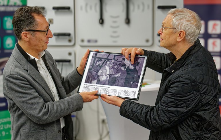 Cem Özdemir bekommt den Zeitungsartikel überreicht