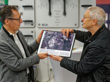 Cem Özdemir bekommt den Zeitungsartikel überreicht