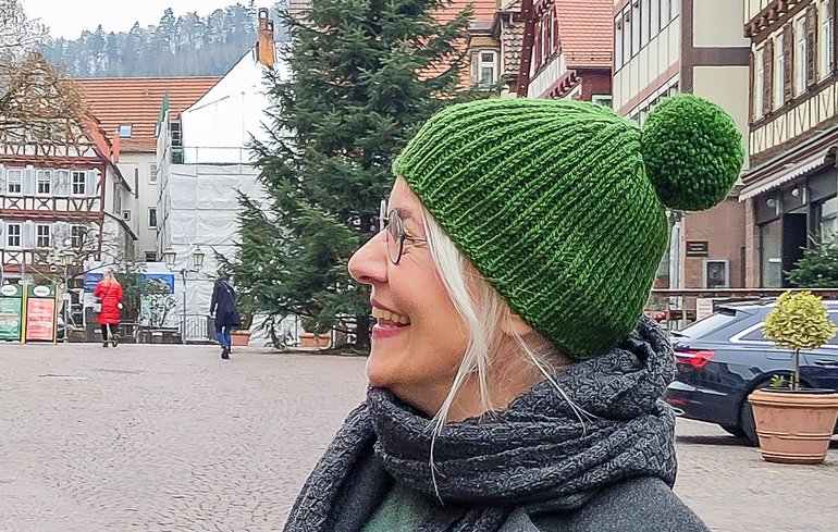 Anke Much trägt ihre selbstgemachte grüne Bommel-Mütze