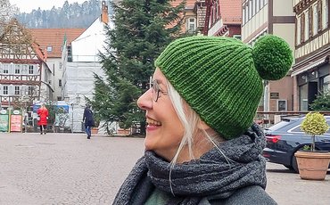 Anke Much trägt ihre selbstgemachte grüne Bommel-Mütze