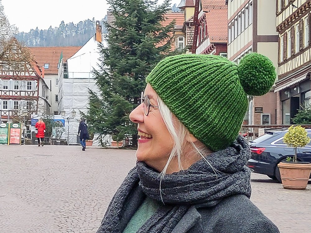 Anke Much trägt ihre selbstgemachte grüne Bommel-Mütze