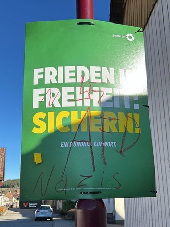 Ein beschmiertes Wahlplakat mit Nazi-Symbolen