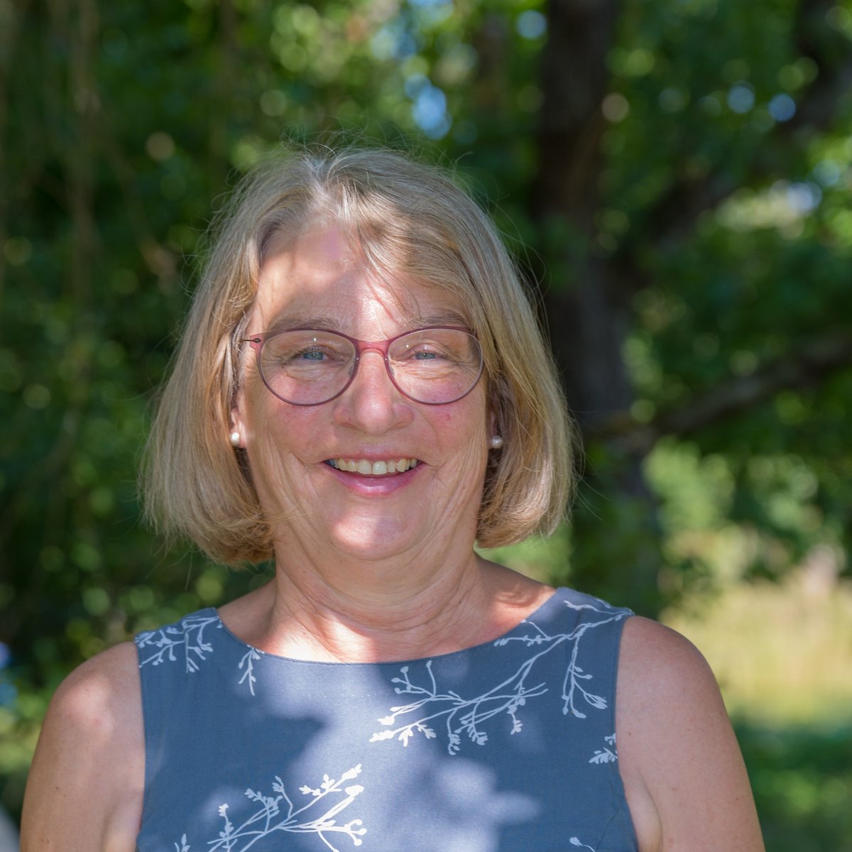 Brigitte Loyal vor einem grünen Hintergrund