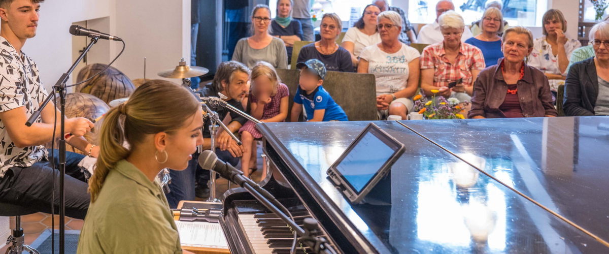 Kiara Huber spielt Klavier während einer Grünen Kulturveranstaltung in der Calwer Kulturapotheke