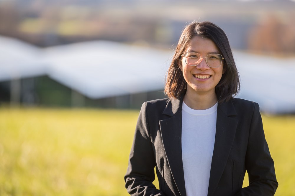 Thuy Nga Trinh steht vor einer Solaranlage