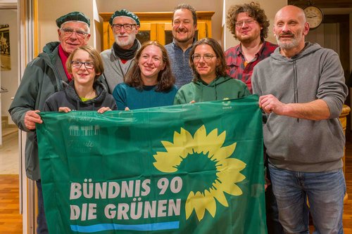 Mitglieder des KV vor einer Grünen Flagge