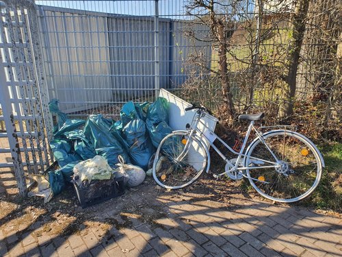 Die Mülltüten und ein kaputtes Fahrrad beim Sammelplatz
