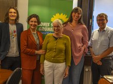 Gruppenbild vor einem grünen Banner