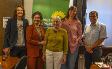 Gruppenbild vor einem grünen Banner