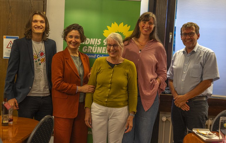 Gruppenbild vor einem grünen Banner
