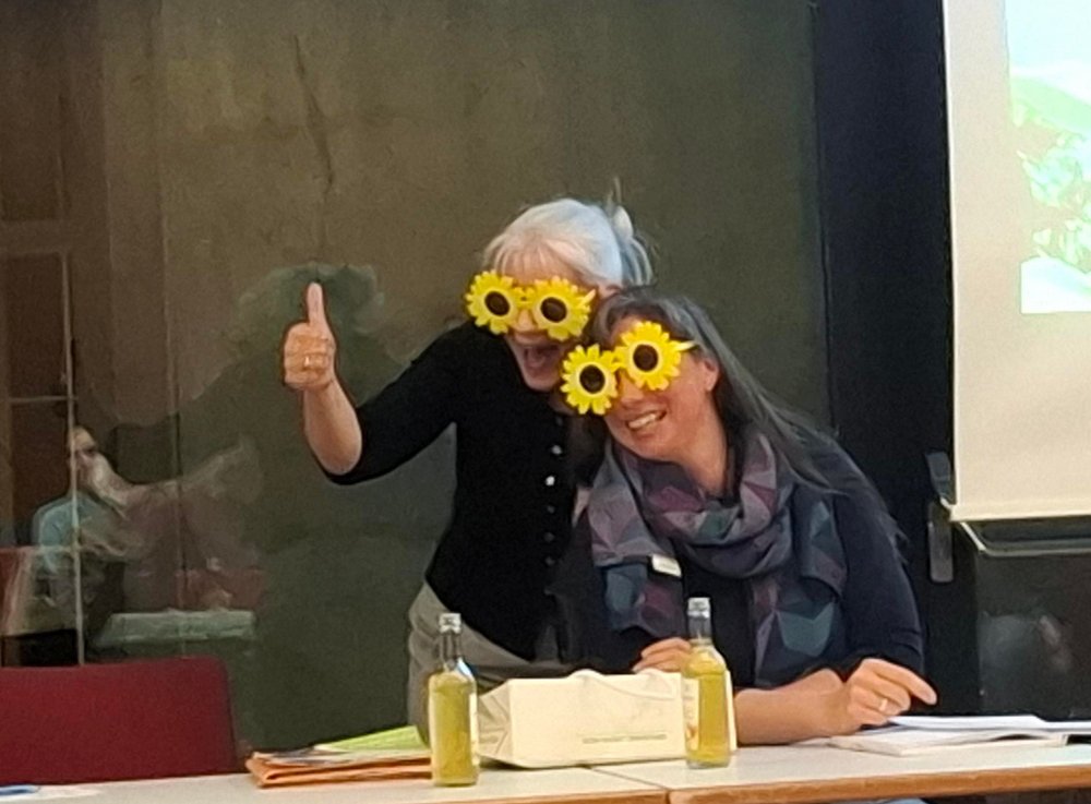 Kreissprecherinnen Anke und Lena bei der Arbeit mit Sonnenblumen-Sonnenbrillen