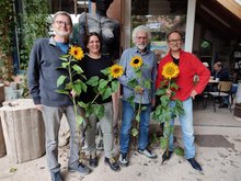 Die Ortvorstände von Bad Liebenzell lächeln in die Kamera und halten Sonnenblumen